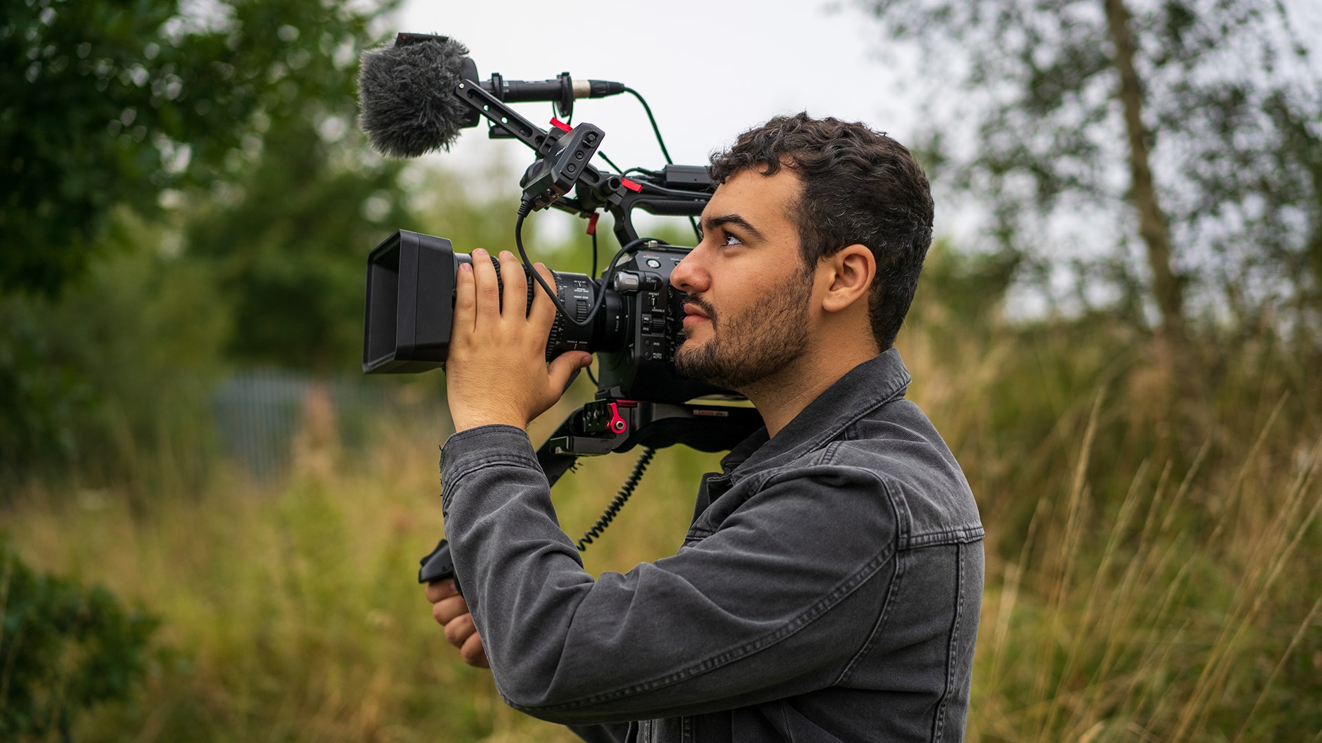 Wildlife presenter Yussef holds camera in field 